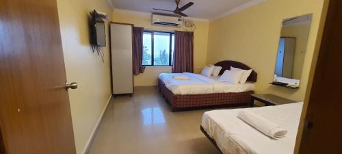 维沙卡帕特南Royal Stay的酒店客房设有两张床和窗户。