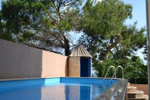 萨武德里亚Villa del Golfo的一座游泳池,旁边是一座小建筑