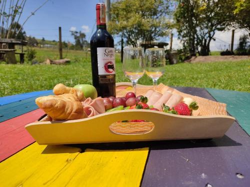 拉卡莱拉Iwoka Ecoturismo的桌上的一盘食物和一瓶葡萄酒