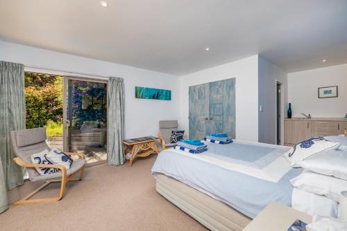 WhangaroaHarbour View的卧室配有床、椅子和窗户。