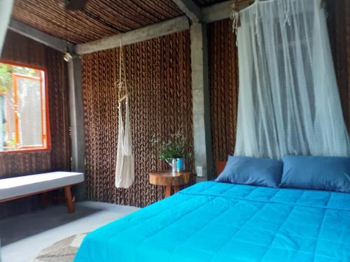 槟知Nông Trại Thảnh Thơi的一间卧室设有蓝色的床和窗户。