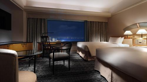 千叶新大谷幕张酒店的酒店客房设有两张床和一张桌子。