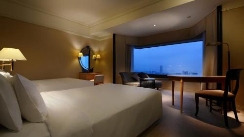 千叶新大谷幕张酒店的配有一张床、一张书桌和一扇窗户的酒店客房