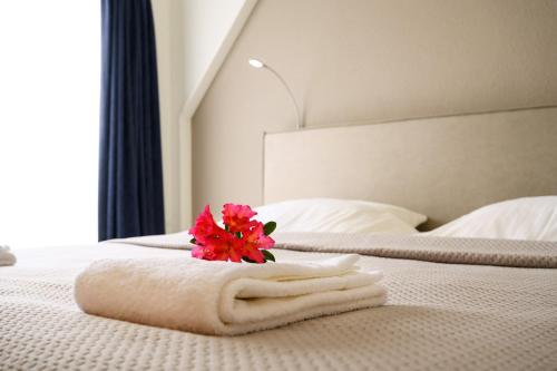 博尔讷亚克洛斯特酒店的白色的床,上面有一条毛巾,上面有花