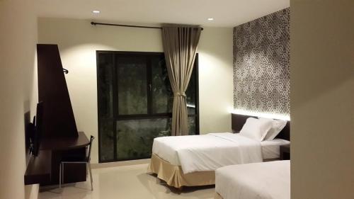 努沙杜瓦白色岩石旅馆的酒店客房设有两张床和窗户。