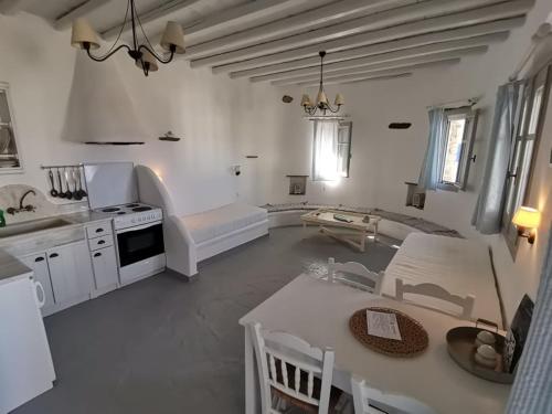 圣罗曼诺斯Elia Apartments的厨房以及带桌椅的起居室。