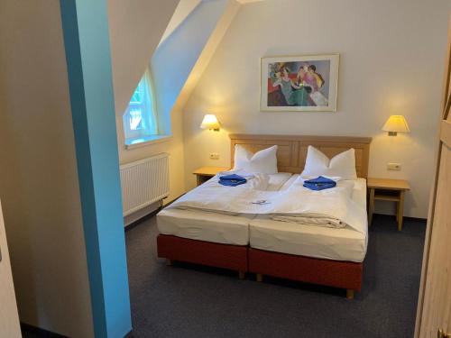 迪特福特斯伽罗维特伽斯特翰斯酒店的一间卧室配有一张带白色床单的床和一扇窗户。
