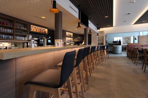 布拉腾Hotel Blattnerhof的酒吧,餐厅里摆放着一排椅子