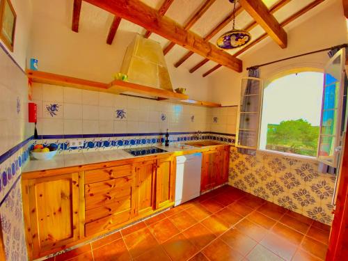 休达德亚Agroestancia Lloc Nou en Ciutadella de Menorca的一个带木制橱柜和大窗户的厨房