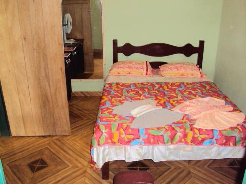 圣罗克迪米纳斯Sitio Sao Benedito的一张带五颜六色的被子的床