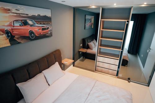 克卢日-纳波卡Thome Arena Residence的卧室配有一张床,墙上挂着一幅汽车画