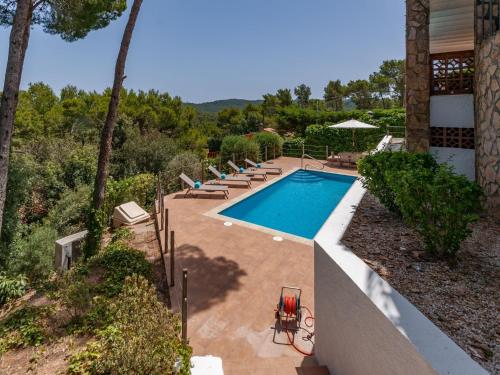 帕尔斯Holiday House with pool and spectacular sea views的一座房子旁带躺椅的游泳池