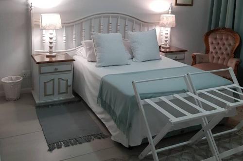 杰弗里湾16 Flame@ Supertubes, Luxury room, Jeffreys Bay的卧室配有白色的床、两张桌子和椅子