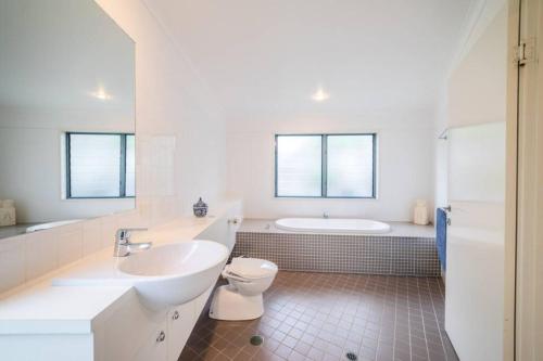 波因特卢考特Saltwater 5 - sleeps 8 - pet friendly的浴室配有盥洗盆、卫生间和浴缸。