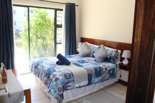 乌旺戈海滩7 Topanga的一间卧室设有一张床和一个大窗户