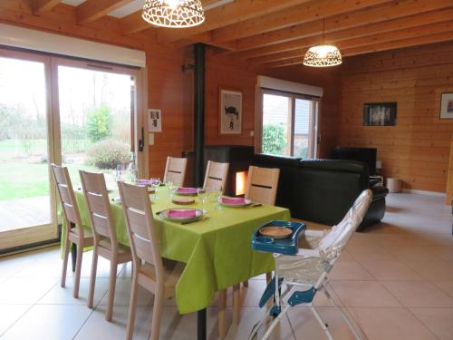 BaudementGîte Autre Ruche的一间带绿色桌椅的用餐室