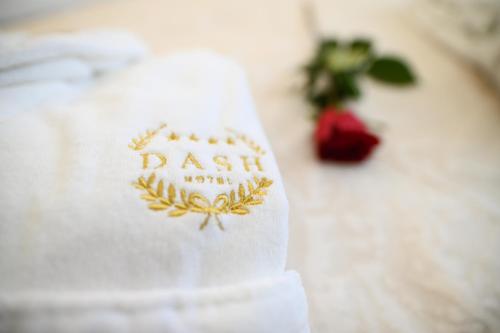 诺维萨德加尔尼丹什酒店的植物旁的白色毛巾,上面有标志
