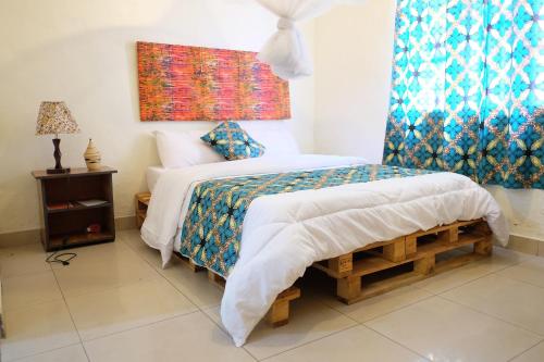 基加利INZOZI AFRICA HOUSE B&B- Kacyiru的一间卧室设有一张床和一个窗口
