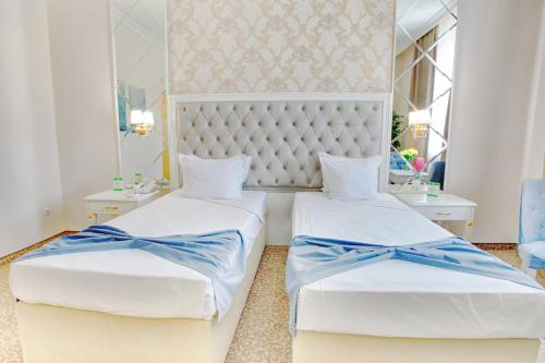 普罗夫迪夫Ramada by Wyndham Plovdiv Trimontium的一间卧室配有两张带蓝色弓的床铺