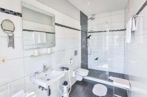 巴登-巴登金狮酒店的白色的浴室设有水槽和卫生间。