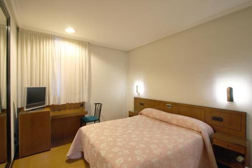 奥维多圣克鲁斯酒店 的酒店客房,配有床和电视
