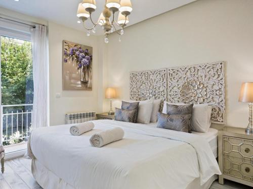 锡切斯Sitges Spaces Mediterranean Apartments 4 bedroom, 4 bathroom, Huge Terrace, Jacuzzi- Sleeps 9的一间卧室配有一张大白色床和两个枕头
