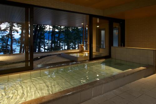 釜石蓬莱罐海滩美食酒店的设有一个按摩浴缸的建筑,设有窗户