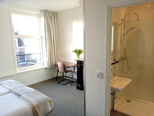 阿姆斯特丹威尔第酒店的酒店客房设有床、水槽和浴室