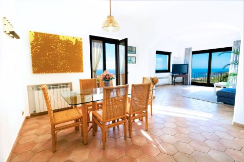 伊斯基亚Villa Titina - Sunset Apartments的一间设有玻璃桌和椅子的用餐室