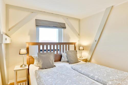 施特拉尔松德Apartmenthaus Tribseer Damm 6的一间卧室配有一张带两盏灯的床和一扇窗户。