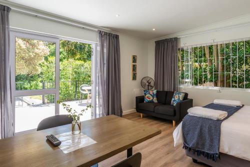 开普敦Oak Manor的一间卧室配有一张床、一张桌子和一张沙发