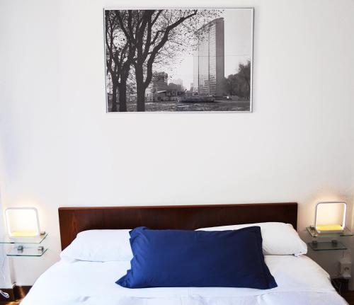米兰鲁姆住宿加早餐旅馆的一间卧室,床上配有蓝色枕头和两盏灯