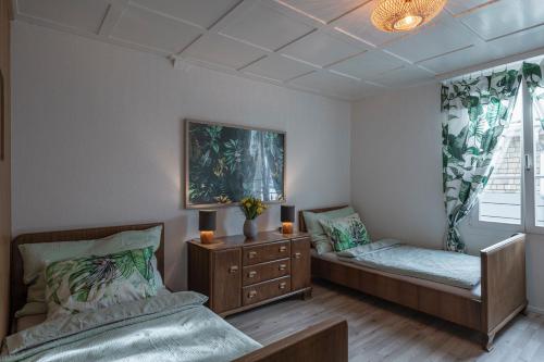 RothenthurmGästezimmer im Dorfzentrum的一间卧室设有两张床、一个梳妆台和窗户。