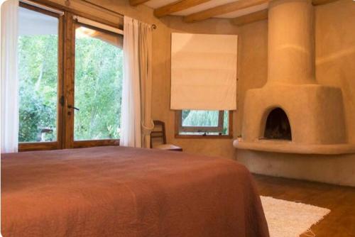 查克拉斯德科里亚Exquisita habitación en suite en el corazón de Chacras de Coria的一间卧室设有一张大床和一个壁炉