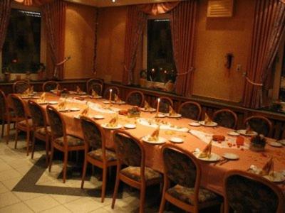 奥斯塔泰弗兰克酒店的大型用餐室配有长桌和椅子