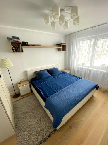 图库姆斯At Telegraph str.的一间卧室配有一张带蓝色床单和吊灯的床。