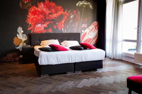 贝克贝亨Hotel Spelderholt的一间卧室配有一张带红色枕头的床
