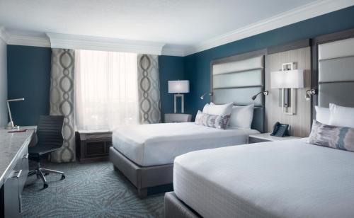 奥兰多奥兰多会议中心罗森中心酒店的酒店客房配有两张床和一张书桌