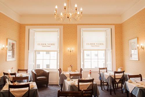 爱丁堡老约克宾馆的一间带桌椅和吊灯的用餐室