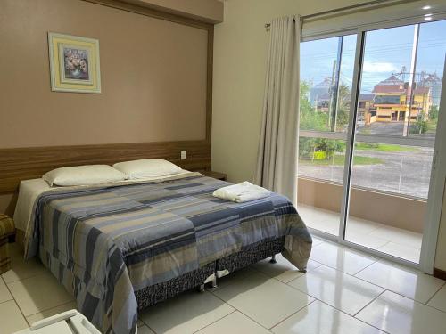 Restinga SêcaPousada Fuzer的一间卧室设有一张床和一个大窗户