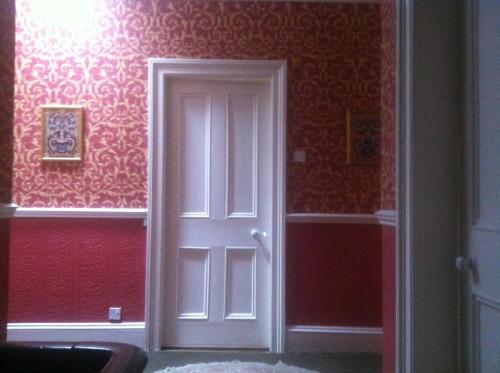 波特劳伊斯艾维蕾住宿加早餐旅馆的红色墙壁的房间里,白色的门