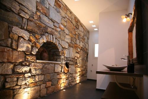 纳克索乔拉Chez Kiki et Ioannis的石墙,浴室设有水槽