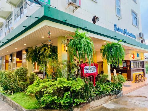 华欣Baan Nilawan Hua Hin Hotel的前面有红色长凳的商店