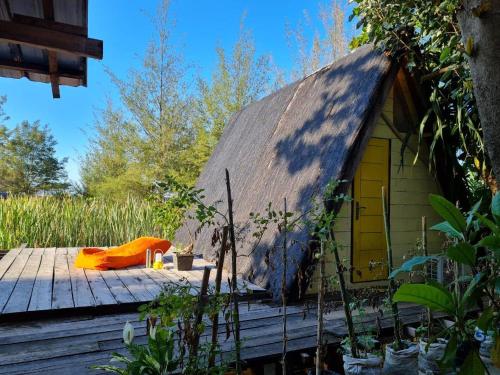 LhongaSaho Coffee & Rooms的木甲板上茅草屋顶的房子