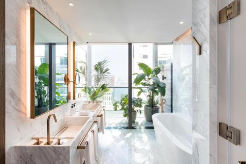 香港The Hari Hong Kong的一间带两个盥洗盆的浴室和一个大窗户