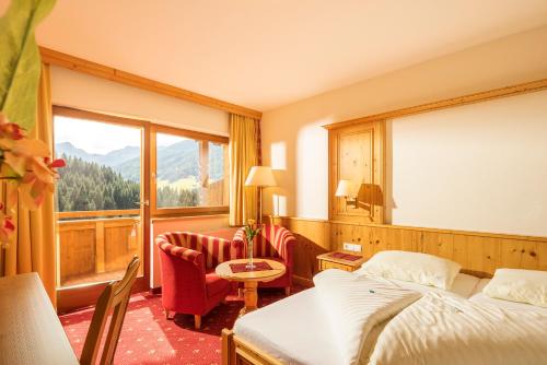 阿尔卑巴赫Hotel Alphof Alpbach的酒店客房设有一张床和一个大窗户
