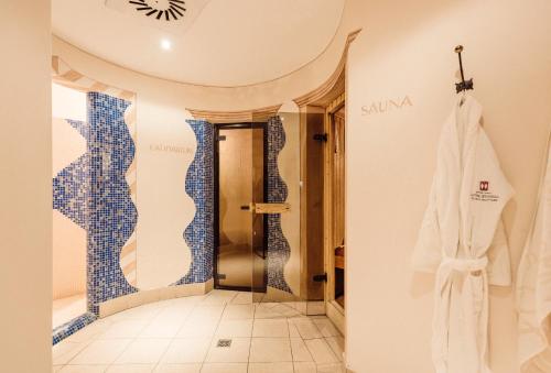 梅拉诺Hotel Castel Rundegg (Adults Only)的浴室的墙壁上铺有蓝色和白色的瓷砖。