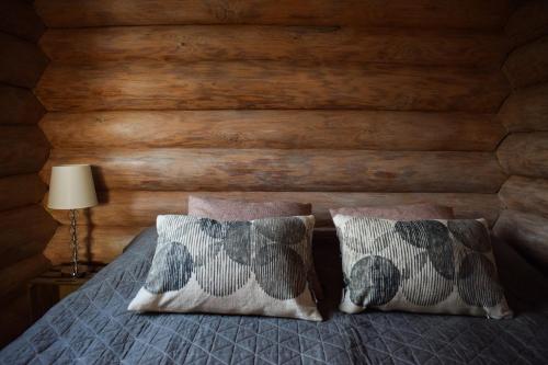 普马拉Loma-Autio Apaja的一间卧室设有木墙,配有一张带两个枕头的床