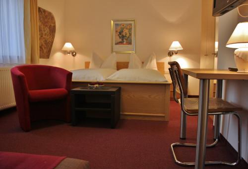 恩格尔哈茨采尔候格斯坦埃德尔家庭膳食公寓酒店的配有一张床和一把椅子的酒店客房