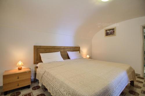 帕图Alfa Ovest的一间卧室配有一张床和一个带两盏灯的床头柜。